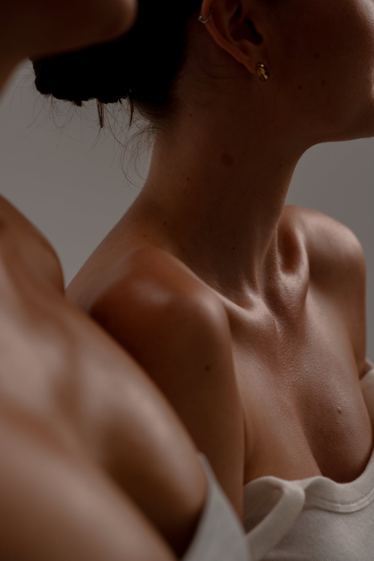 Close-up of glowing, moisturised skin on a woman’s shoulder after body oil
