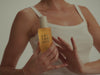 Woman pumping Sonoma Sunset body oil into her palm, a lightweight body oil for an at-home spa ritual